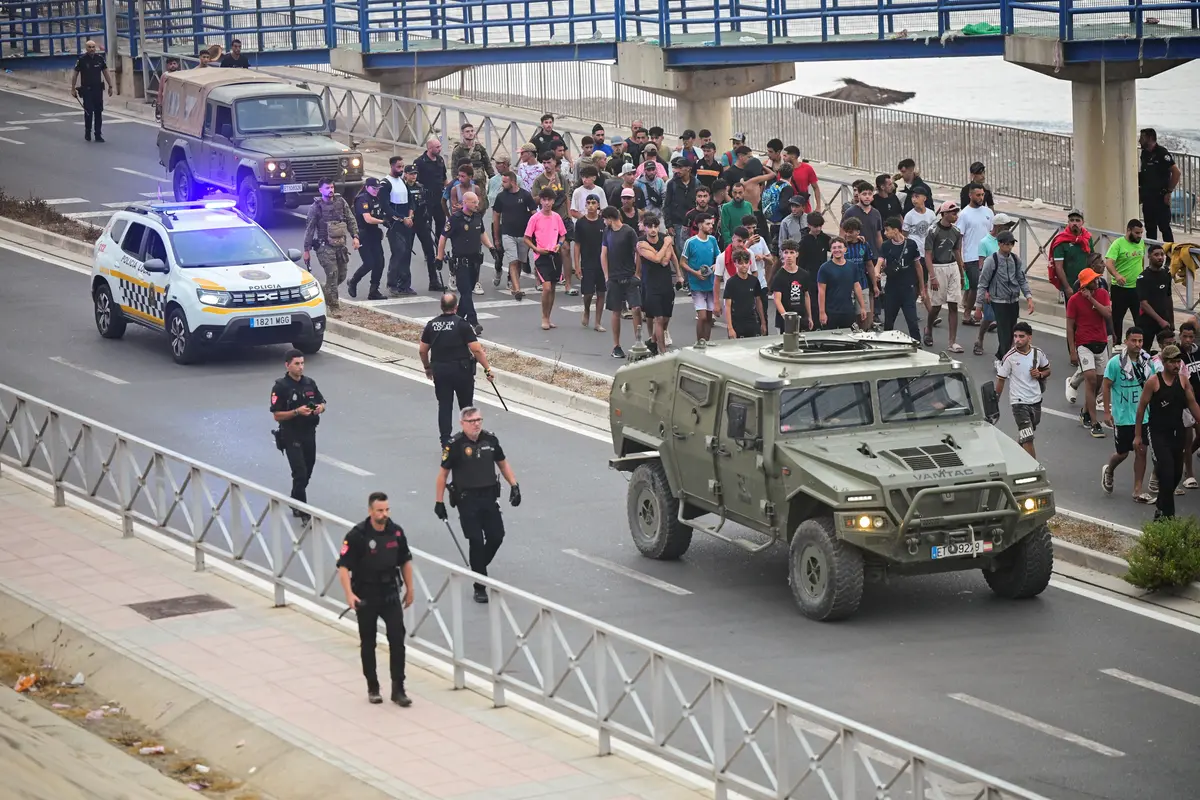 Policja i wojsko na ulicy w Ceucie podczas eskorty migrantów do granicy