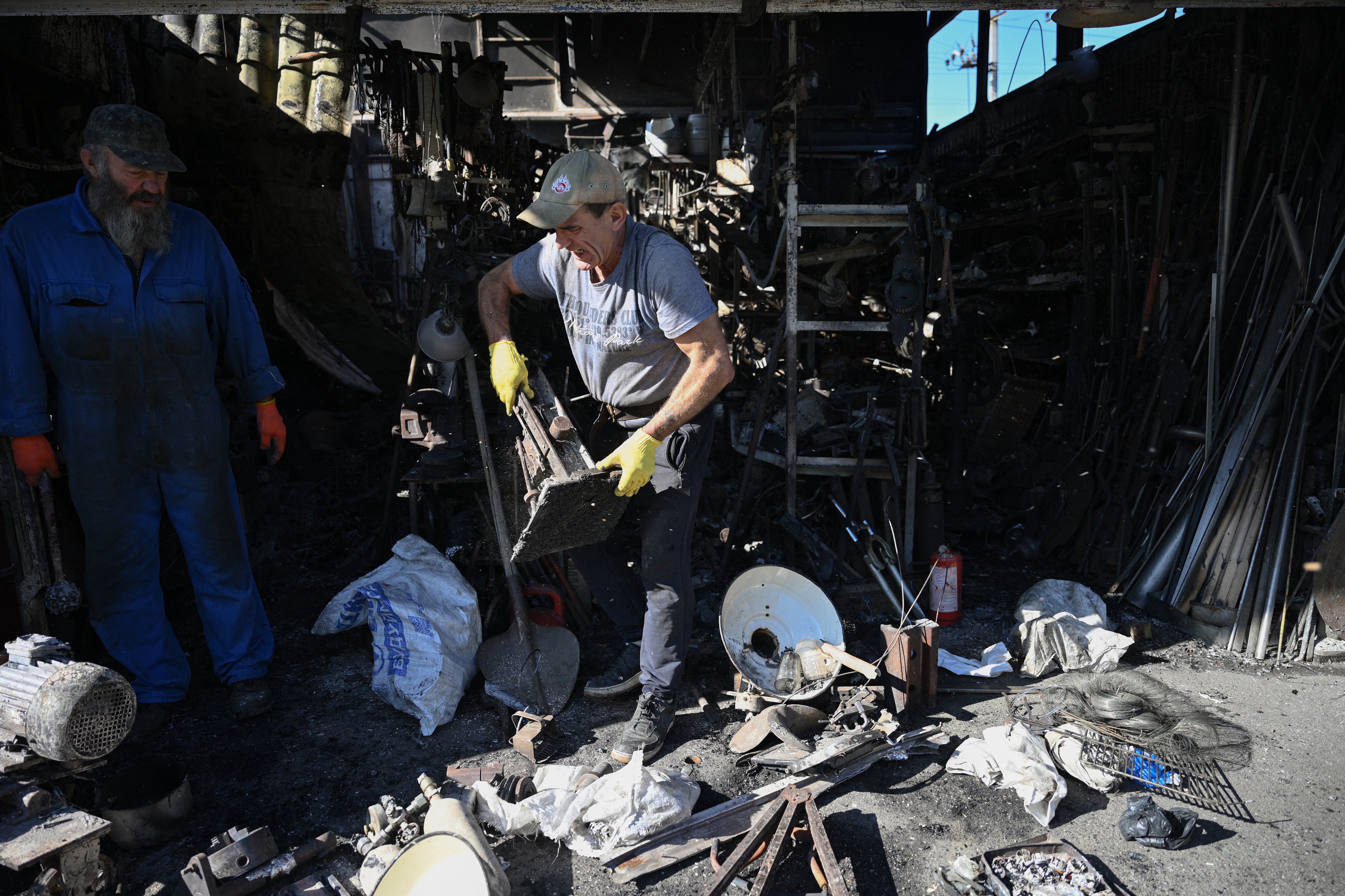 Vendors inspect their damaged stall at a market in Kyiv, Ukraine’s capital