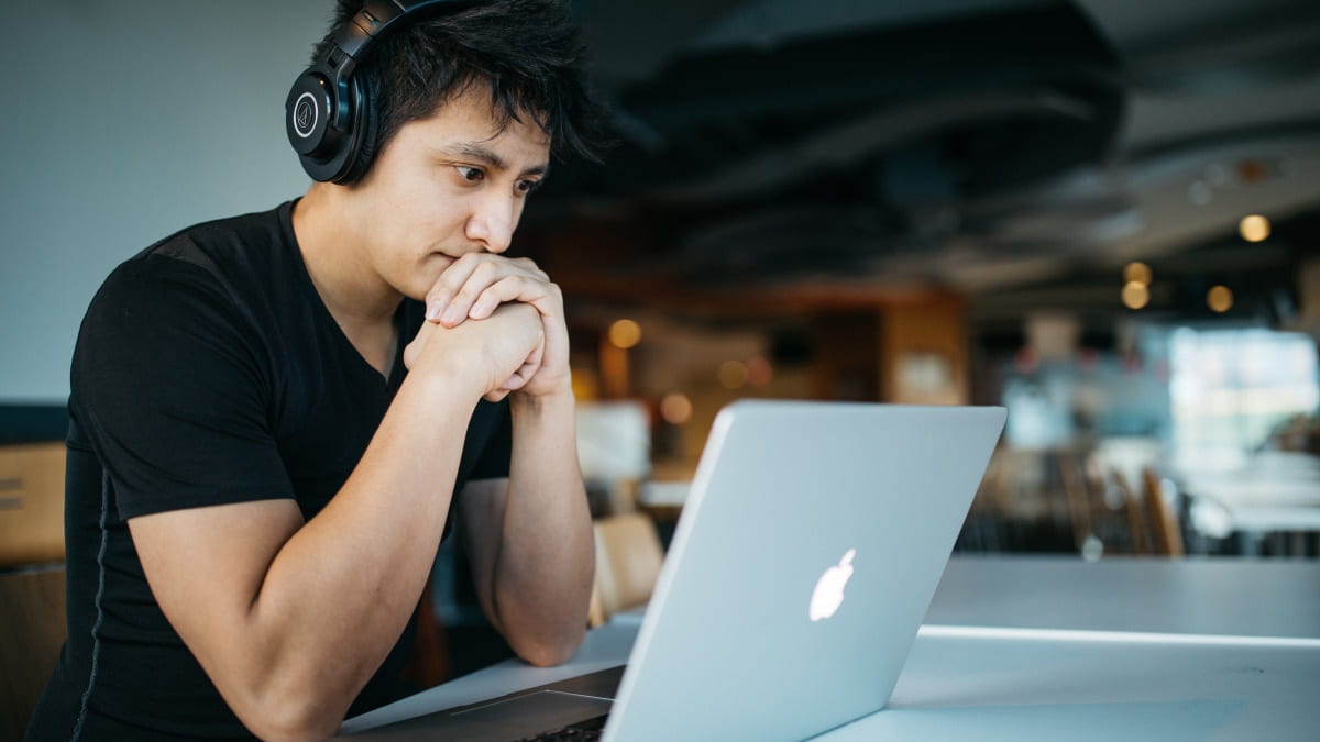 Um rapaz que pode ser um estudante a usar um computador