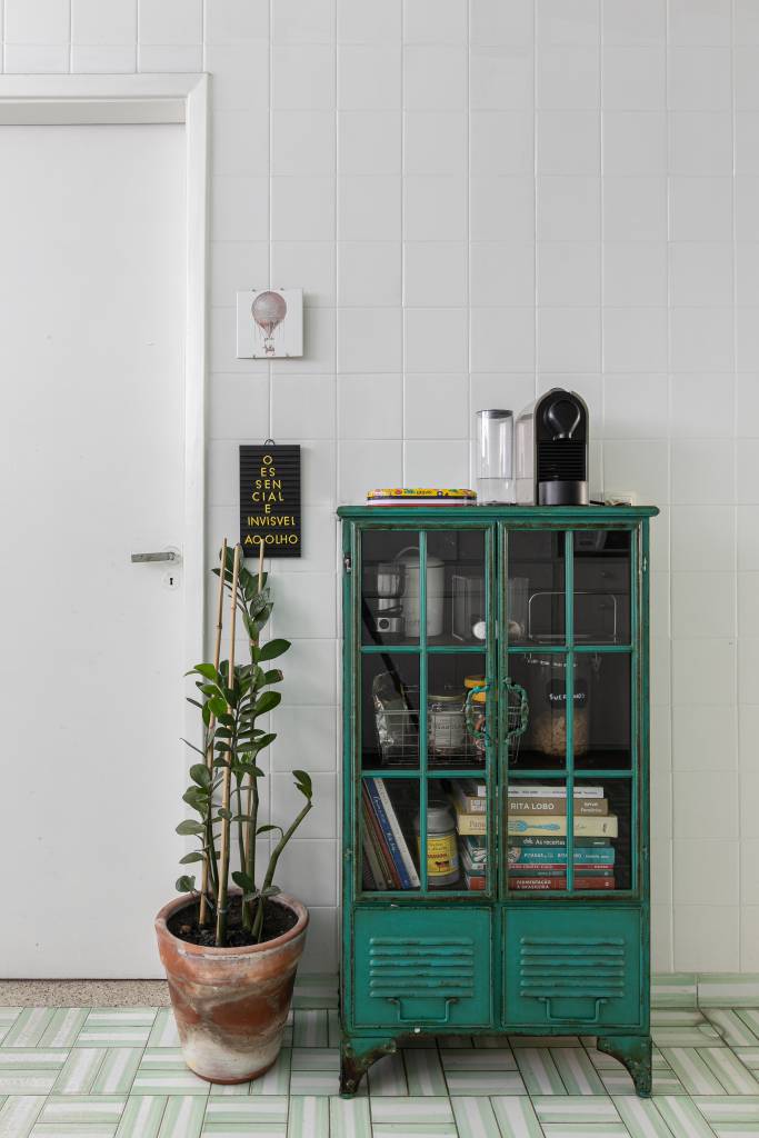 Apartamento tem teto amarelo e charmosa cozinha em tom verde menta. Projeto de Pro.a Arquitetos.