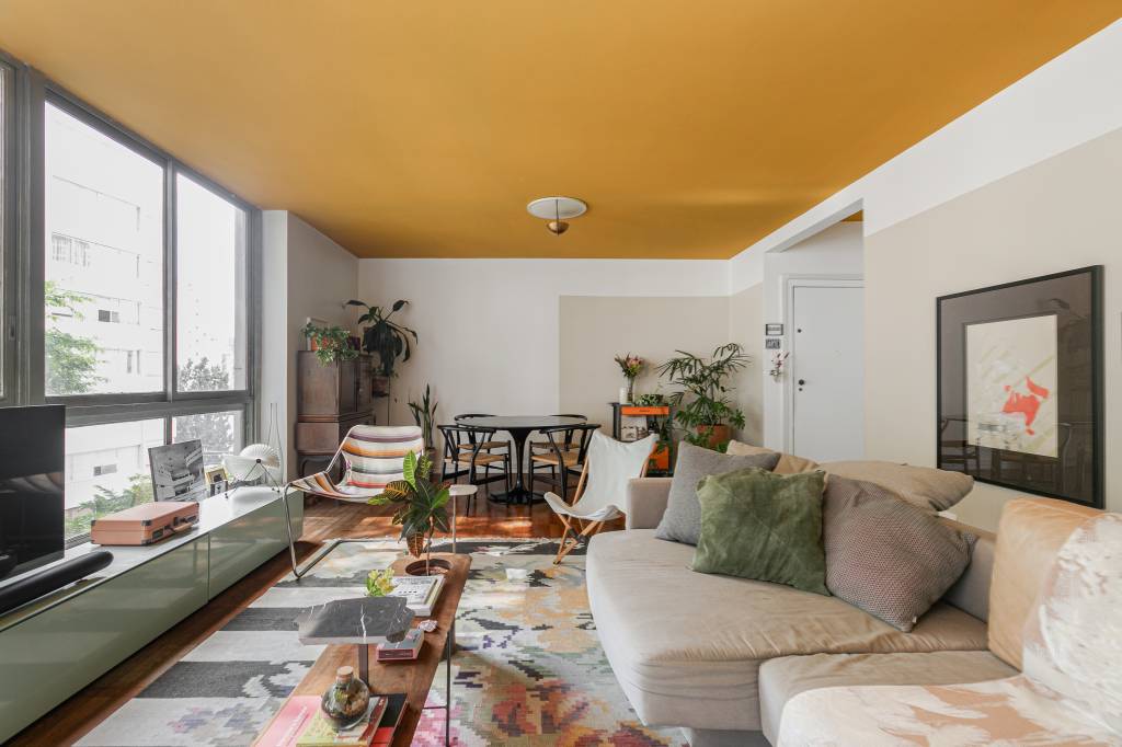 Apartamento tem teto amarelo e charmosa cozinha em tom verde menta. Projeto de Pro.a Arquitetos.
