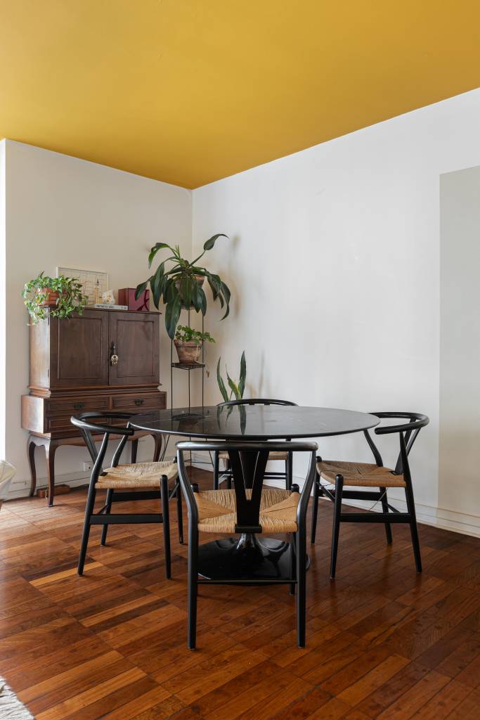 Apartamento tem teto amarelo e charmosa cozinha em tom verde menta. Projeto de Pro.a Arquitetos.