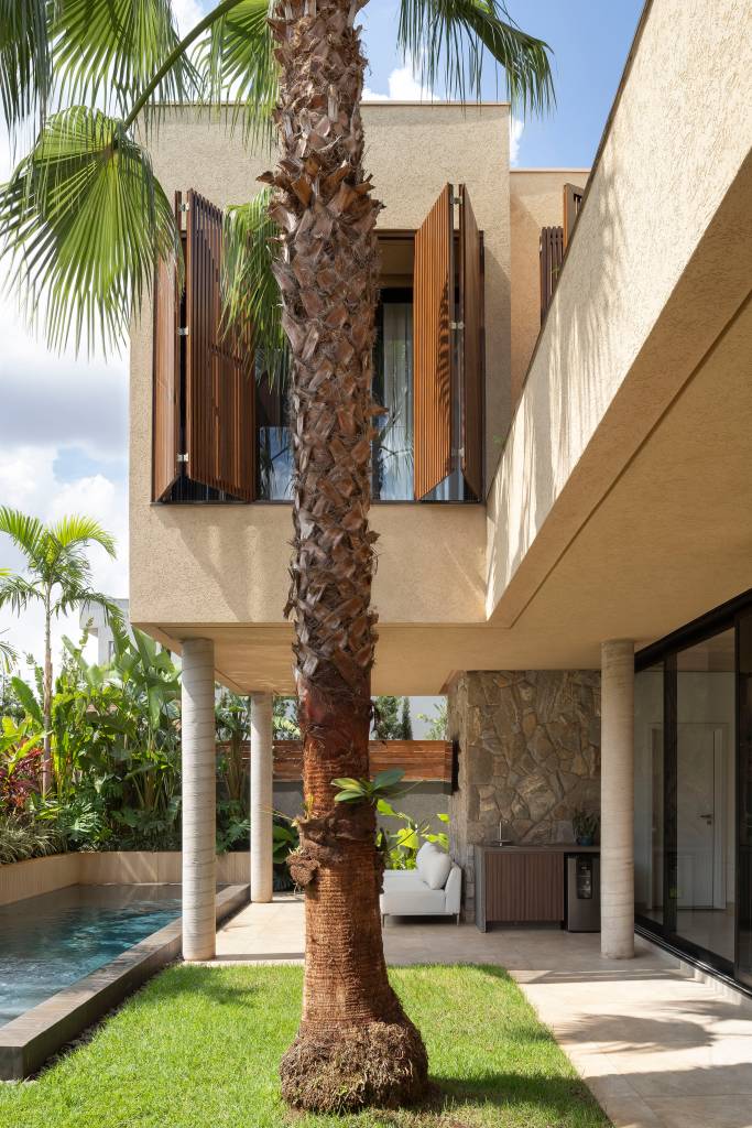 Casa moderna tem pedras rústicas de granito amarelo e cobogós na fachada. Projeto de WA Arquitetura.