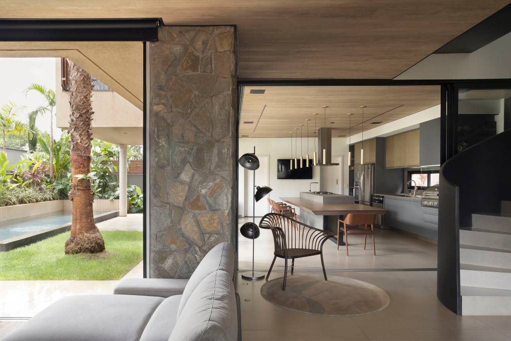 Casa moderna tem pedras rústicas de granito amarelo e cobogós na fachada. Projeto de WA Arquitetura.