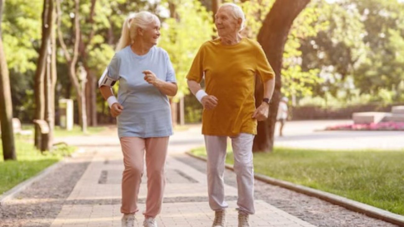 na foto aparece um casal que tenta caminhar rápido na velhice para manter a forma 