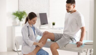 MÃ©dica examinando a perna de um homem sentado em uma maca