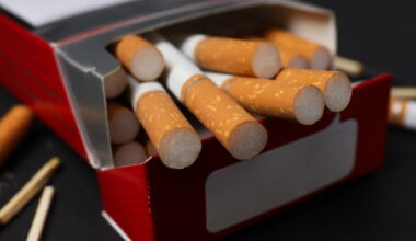 Caixa de cigarros aberta com cigarros a sair. Foco nos filtros