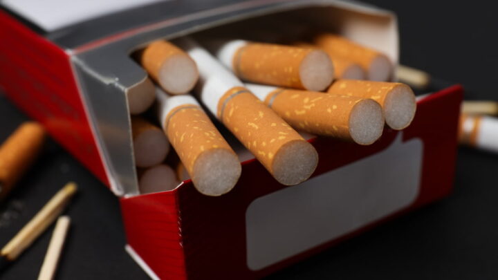 Caixa de cigarros aberta com cigarros a sair. Foco nos filtros