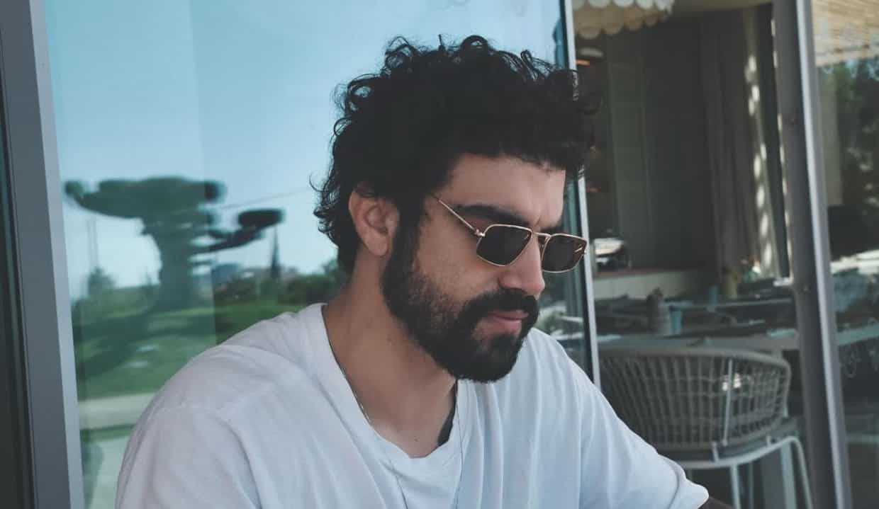 Caio Castro sério, de óculos escuros, cabisbaixo