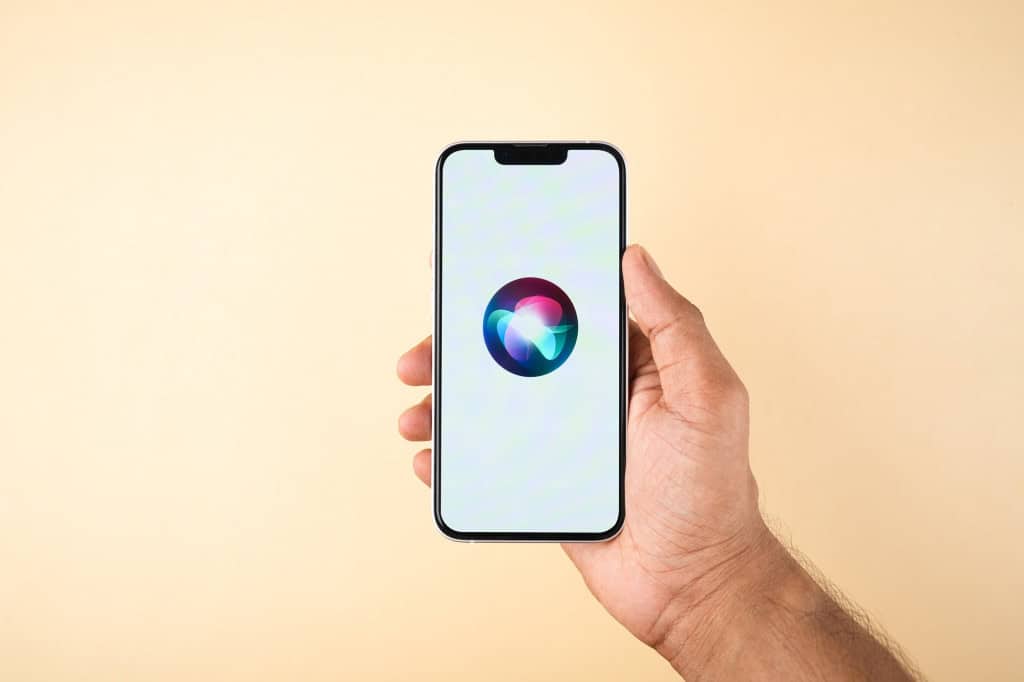 Logo da Siri em um iPhone que está na mão de uma pessoa