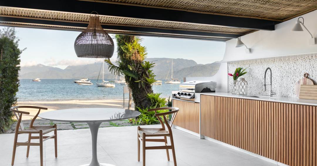 Telhado em bambu natural trançado cobre varanda gourmet de casa de praia
