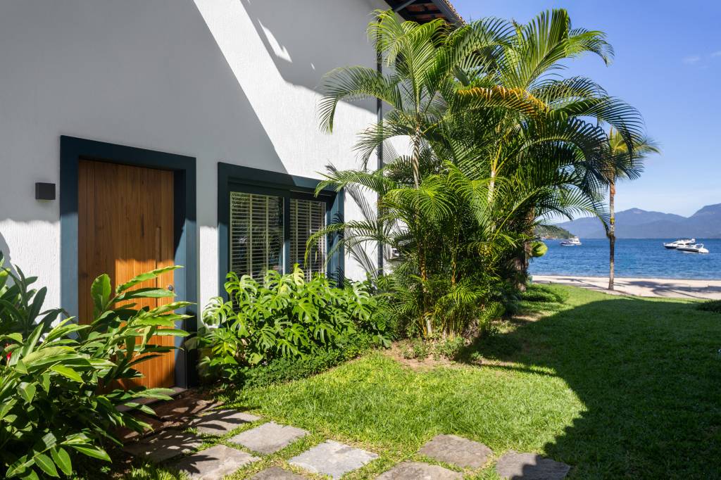 Telhado em bambu natural trançado cobre varanda gourmet de casa de praia. Projeto de A+G Arquitetura.