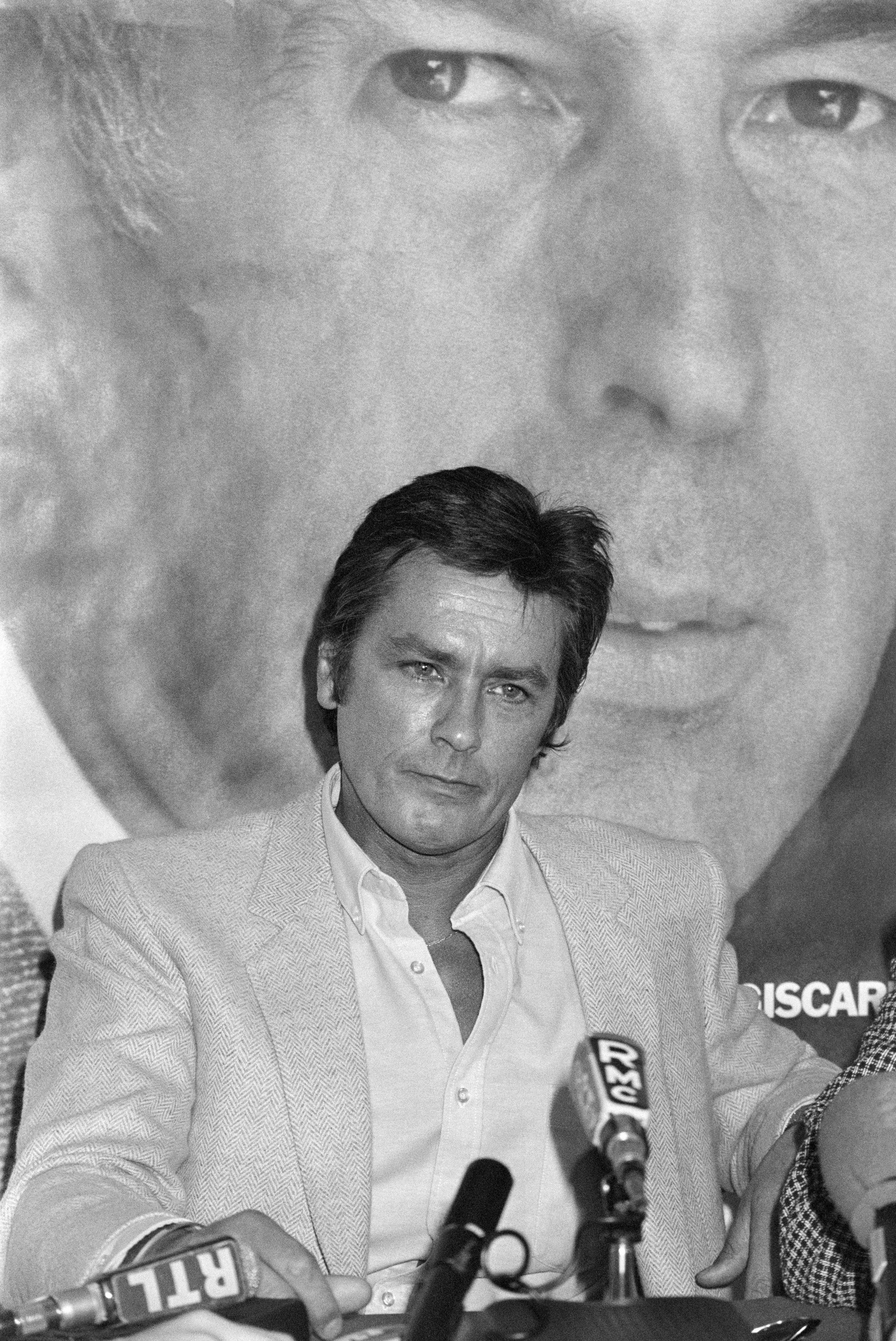 Alain Delon em 1981 em Paris durante campanha eleitoral do ex-presidente Valery Giscard d'Estaing (ao fundo) — Foto: Dominique FAGET / AFP