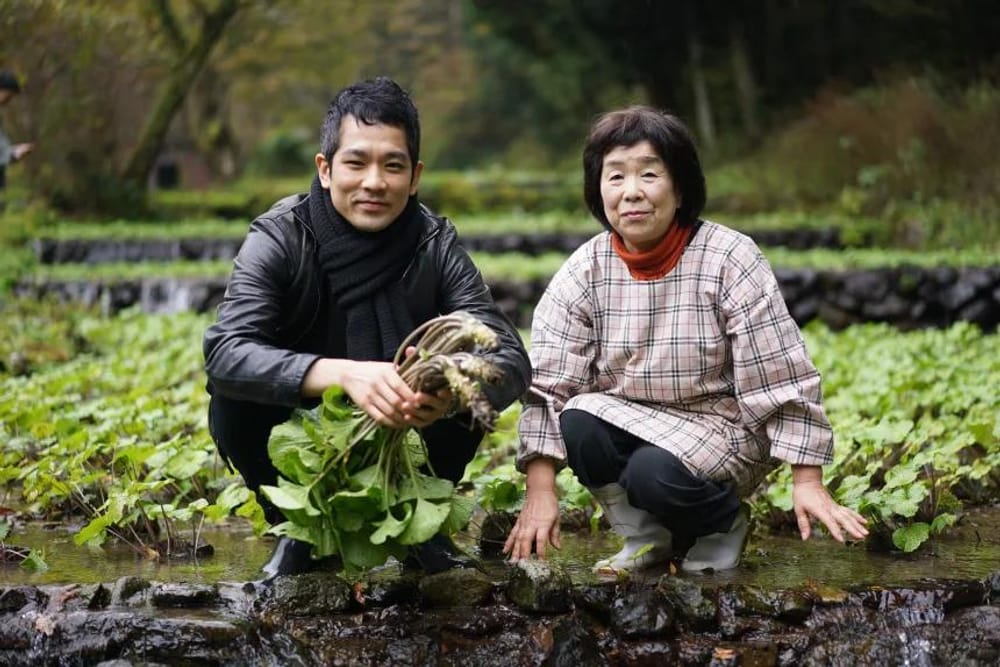 O chefe Yosuke Suga e a sua equipa fazem viagens mensais pelo Japão para conhecer produtores, como este cultivador de wasabi (Cortesia: Sugalabo)