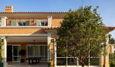 Tijolinhos, telhas de barro, madeira e mármore compõem casa em estilo toscano