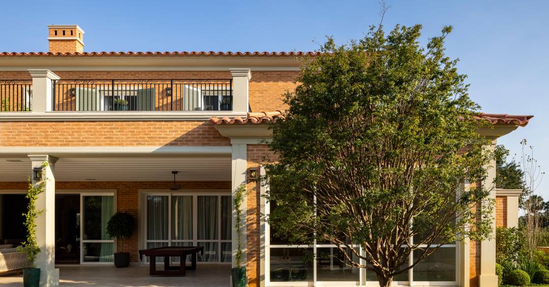 Tijolinhos, telhas de barro, madeira e mármore compõem casa em estilo toscano