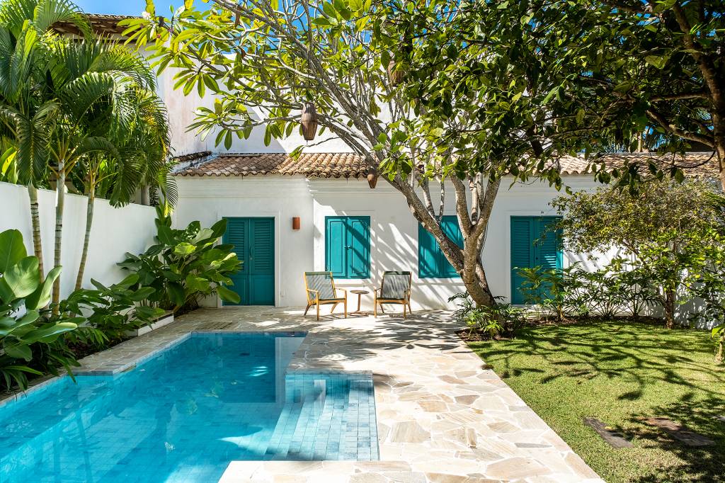 Casa em Trancoso integrada à natureza tem quartos de hóspedes na edícula. Projeto de Conrado Ceravolo. Na foto, fachada com jardim. piscina e varanda.
