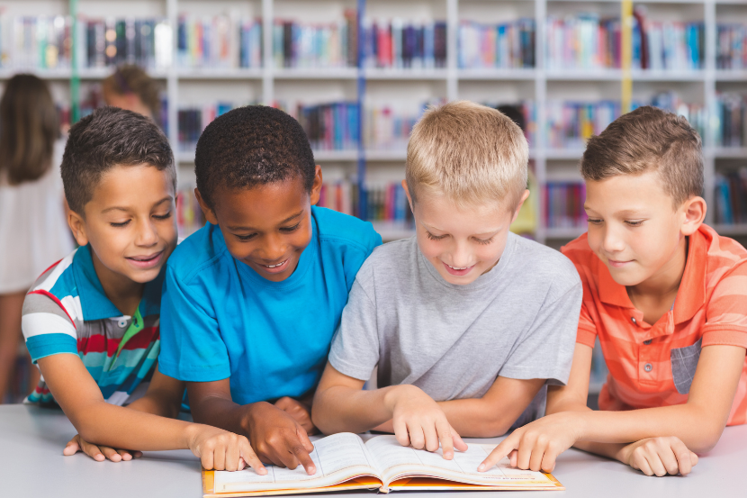 crianças lendo um romance na biblioteca