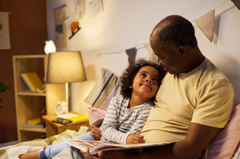 pai lendo para filho na cama na hora de dormir