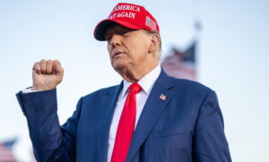 Donald Trump com boné MAGA e punho cerrado