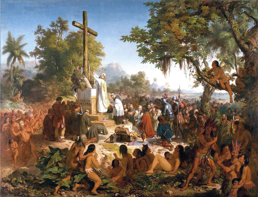 Esta imagem é a famosa e grandiosa pintura histórica "A Primeira Missa no Brasil", de Victor Meirelles. A obra retrata uma cena ao ar livre, em uma paisagem tropical exuberante, representando o primeiro contato religioso entre portugueses e os povos indígenas do Brasil.

O ponto central é um altar improvisado onde um padre, de vestes brancas e solenes, celebra a missa diante de uma grande cruz de madeira. Ao redor do altar, estão os colonizadores portugueses — vestidos com trajes da época, incluindo armaduras, roupas nobres e hábitos de frades — todos concentrados na cerimônia.

Em um grande semicírculo em volta dos portugueses, uma multidão de indígenas, com os corpos nus ou seminus, observa o ritual com expressões de curiosidade, espanto e fascínio. Suas posturas são variadas: alguns estão sentados no chão, outros de pé, e há até quem suba em uma árvore para ter uma visão melhor da cena. A pintura transmite uma atmosfera idealizada de um encontro pacífico e solene, marcando um momento fundador na história do país.