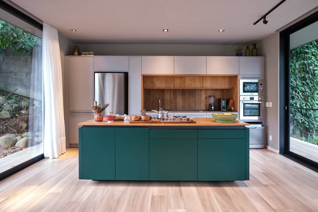 Árvore marca transição entre área social e íntima nesta casa no mato. Projeto de Thimi Arquitetura.