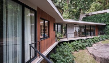 Árvore marca transição entre área social e íntima nesta casa no mato