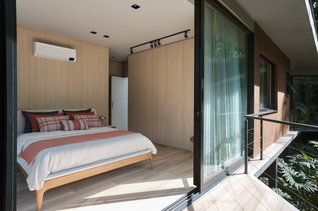 Árvore marca transição entre área social e íntima nesta casa no mato. Projeto de Thimi Arquitetura.