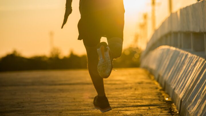 Pessoa a correr durante o pôr do sol; apenas os pés visíveis