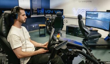 Condutor remoto da Vay, a operar um carro, por via de um volante e com auriculares. À sua volta, vários ecrãs, onde se lê "VAY" e cadeiras gaming