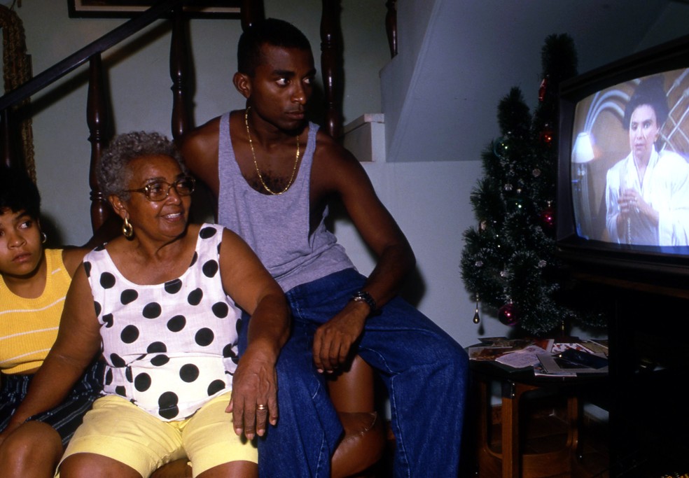 Dona Zica (sambista) e os netos assistem ao capítulo da novela em que a vilã Odete Roitman é assassinada — Foto: William de Moura / Agência O Globo - Cromo: 89-273-A