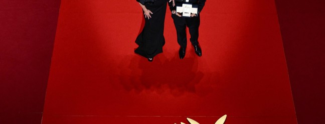 O diretor brasileiro Kleber Mendonça Filho recebe o prêmio de Melhor Ator em nome do ator Wagner Moura durante a cerimônia de encerramento da 78ª edição do Festival de Cannes, em Cannes, sul da França. — Foto: Foto: Valery HACHE / AFP