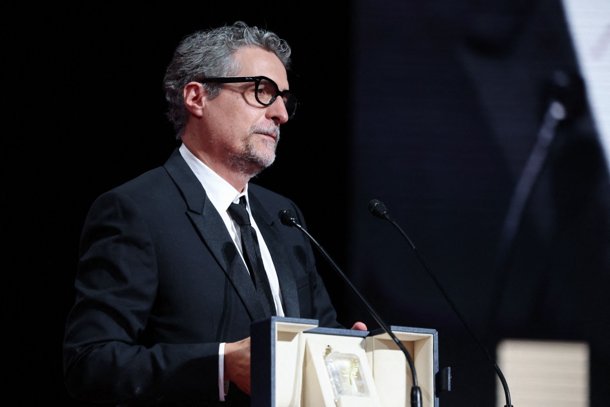 O diretor brasileiro Kleber Mendonça Filho recebe o prêmio de Melhor Ator em nome do ator Wagner Moura durante a cerimônia de encerramento da 78ª edição do Festival de Cannes, em Cannes, sul da França. — Foto: Foto: Valery HACHE / AFP