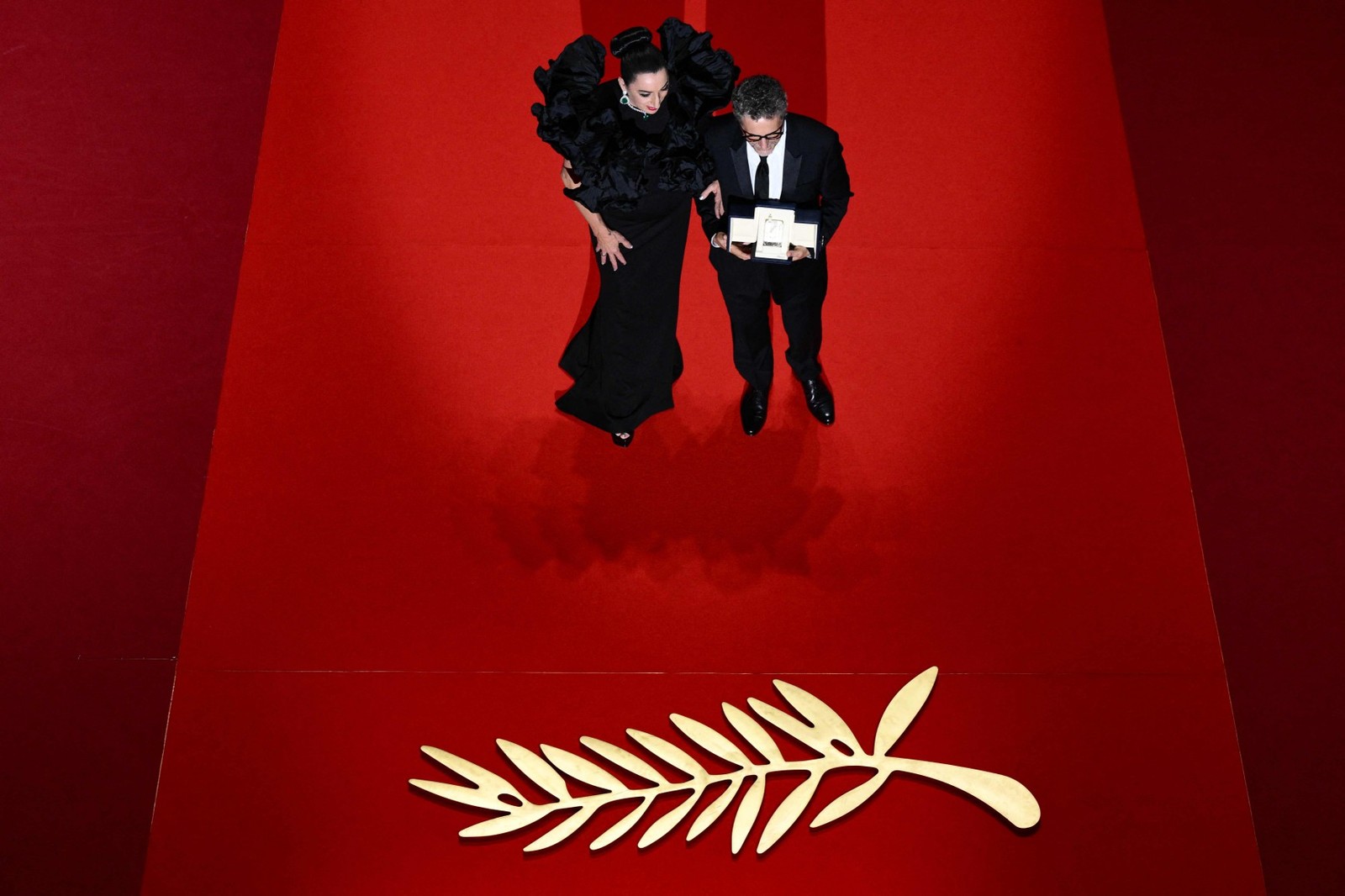 O diretor brasileiro Kleber Mendonça Filho recebe o prêmio de Melhor Ator em nome do ator Wagner Moura durante a cerimônia de encerramento da 78ª edição do Festival de Cannes, em Cannes, sul da França. — Foto: Foto: Valery HACHE / AFP