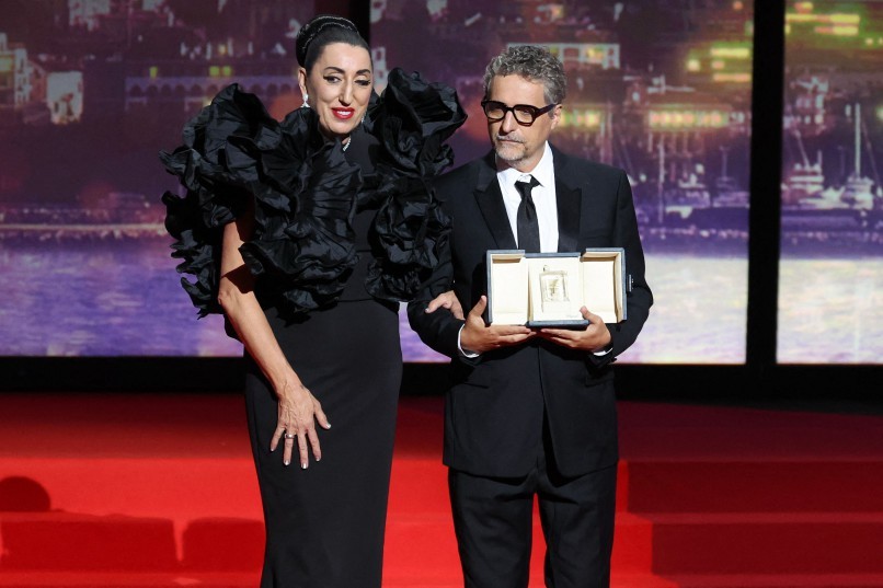 O diretor brasileiro Kleber Mendonça Filho recebe o prêmio de Melhor Ator em nome do ator Wagner Moura durante a cerimônia de encerramento da 78ª edição do Festival de Cannes, em Cannes, sul da França. — Foto: Foto: Valery HACHE / AFP