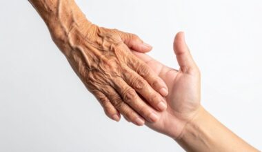 mãos de idoso e jovem entrelaçadas