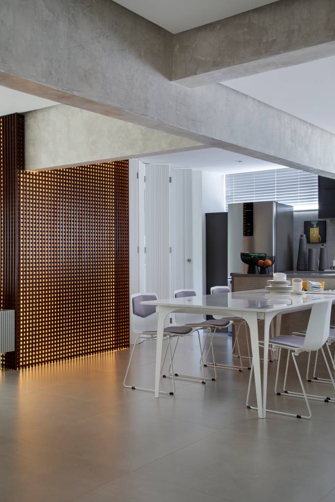 Apê elegante em tons de cinza tem painel de muxarabi iluminado com tela tensionada. Projeto de Anna Fadul.