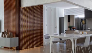 Apê elegante em tons de cinza tem painel de muxarabi iluminado com tela tensionada