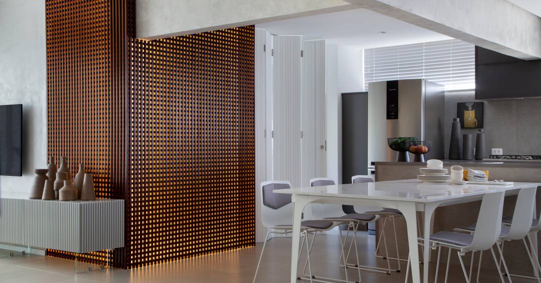 Apê elegante em tons de cinza tem painel de muxarabi iluminado com tela tensionada