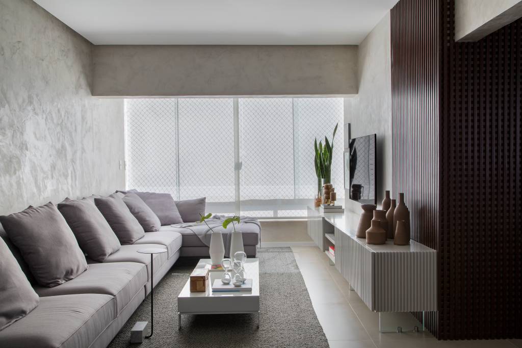 Apê elegante em tons de cinza tem painel de muxarabi iluminado com tela tensionada. Projeto de Anna Fadul.