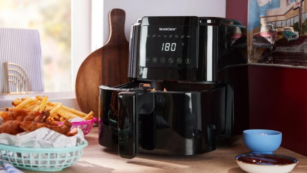 Novo eletrodoméstico a ar quente do tipo fritadeira, modelo digital em bancada de cozinha, preparando alimentos como batatas fritas