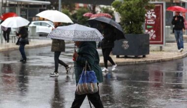 Pessoas na rua em dia de chuva. Crédito: Lusa
