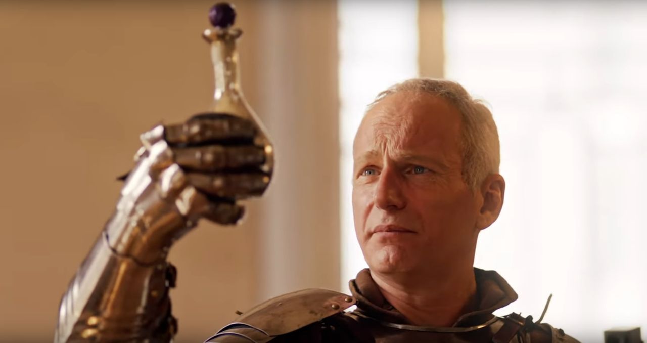 Larian diz que precisará focar mais na otimização de Divinity do que o planejado devido aos preços da RAM e SSD 1 Homem de meia-idade com armadura medieval, segurando uma espada, com fundo desfocado em tons quentes.