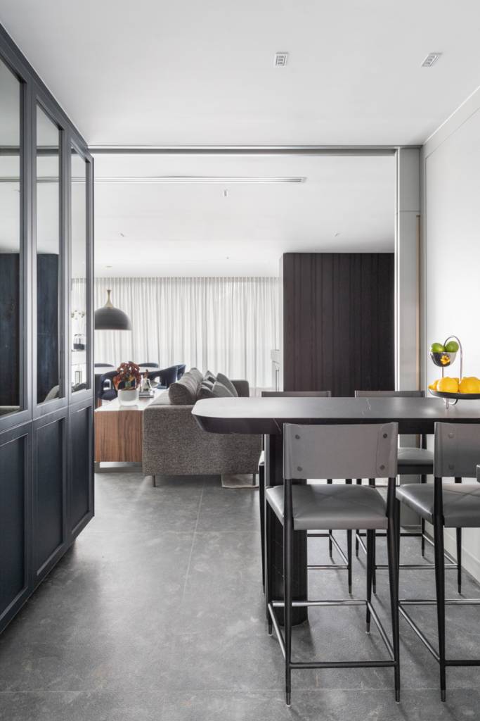 Elegância sóbria: tons de cinza e painéis de madeira ebanizada marcam apê. Projeto de Sabrina Salles.
