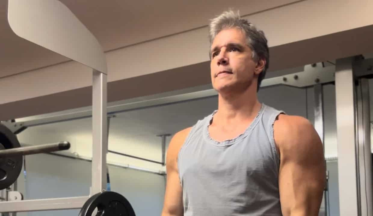 Márcio Garcia de regata cinza, levantando peso na academia