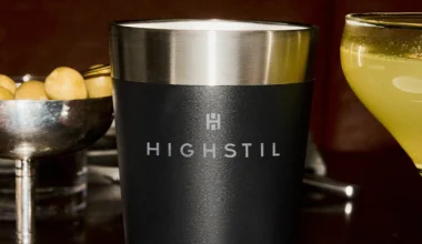 A imagem traz um copo da marca Stanley de cor preta e borda superior prateada.