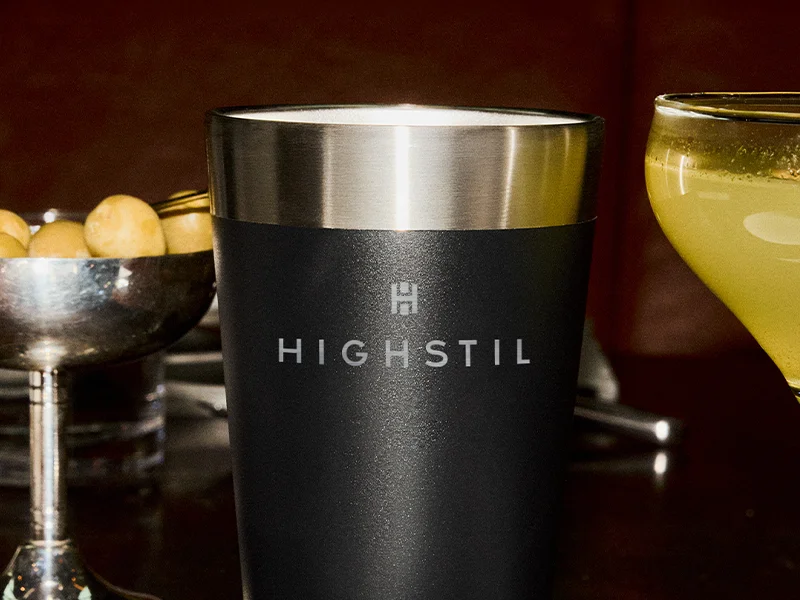 A imagem traz um copo da marca Stanley de cor preta e borda superior prateada.