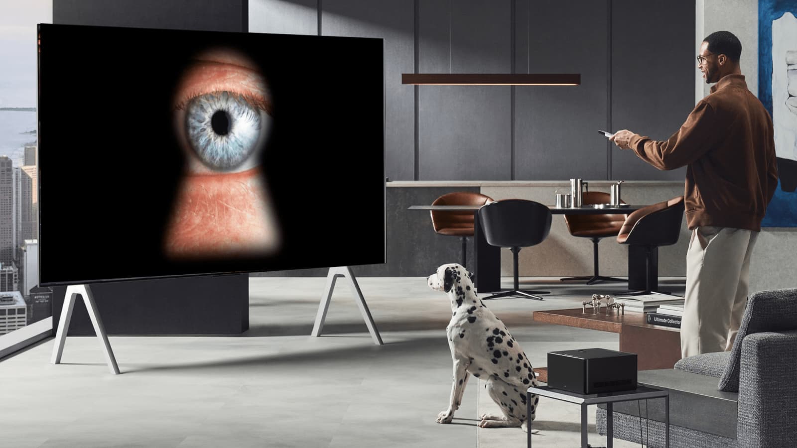 Homem na sala de estar a mexer no comando da televisão. Na televisão uma fechadura a mostrar um olho