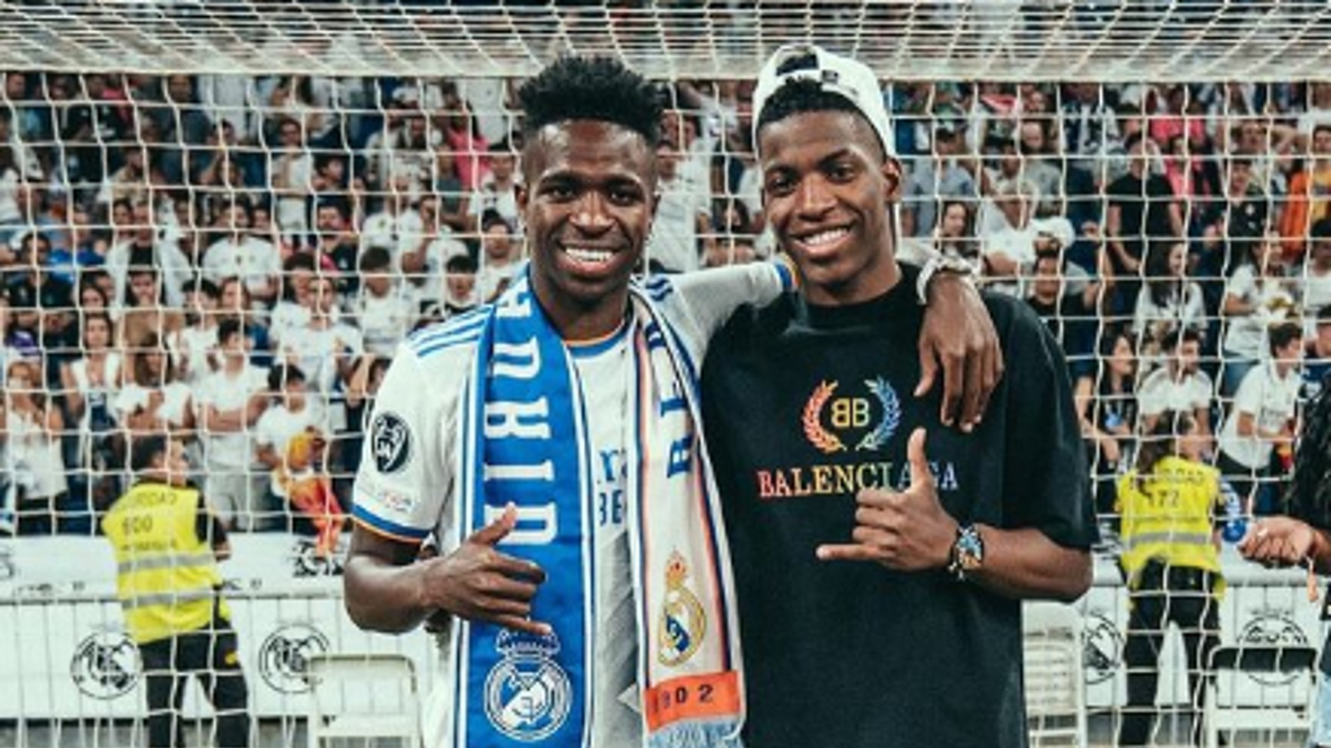 Jogador Vini Jr. e irmão Netinho posam para foto em campo