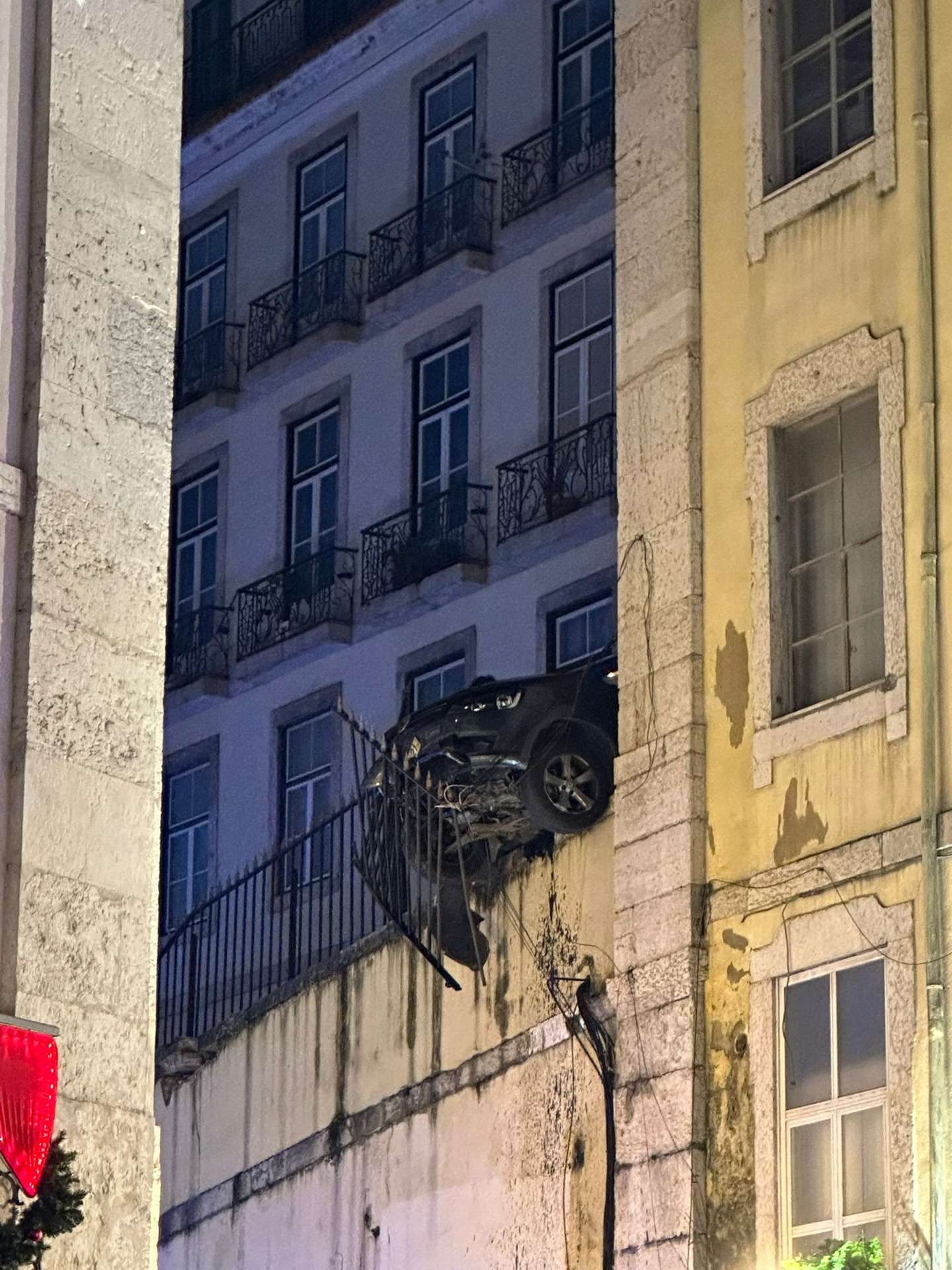 Carro pendurado na Travessa do Cotovelo, em Lisboa, após colisão